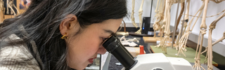 A student uses the microscope to examine a specimen